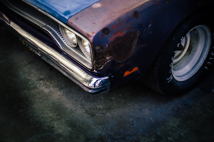 Close-up of a vintage purple car's front fender and wheel