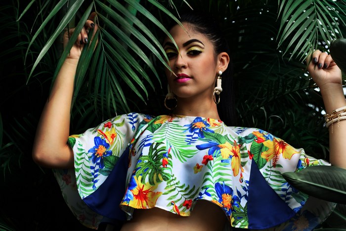 Woman in tropical floral top with palm leaves