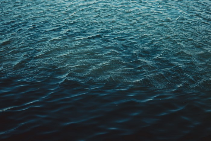 Blue ocean waves with sunlight reflections