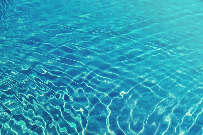 Sunlit Turquoise Swimming Pool Surface with Ripples
