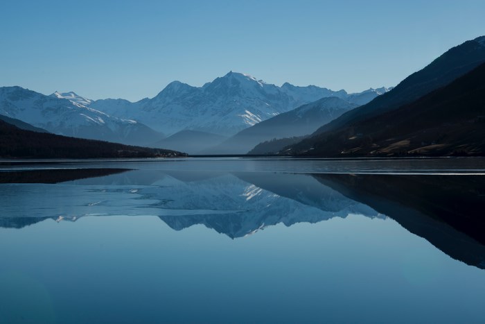 Snow-capped mountains reflected in a calm lake