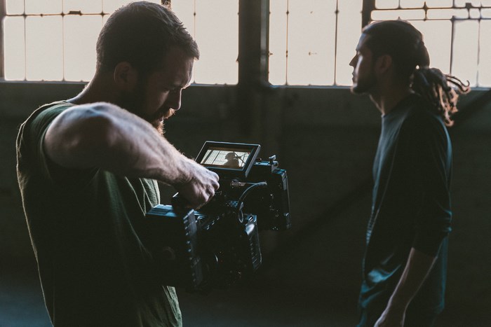 Man filming another man with a video camera
