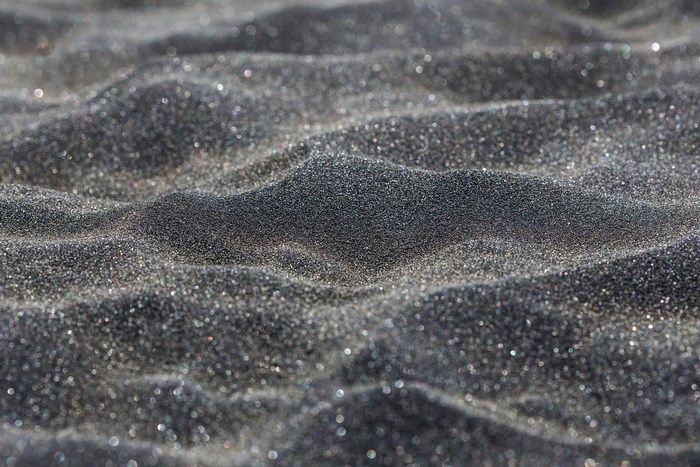 Close-up of black sand dunes with sparkling particles