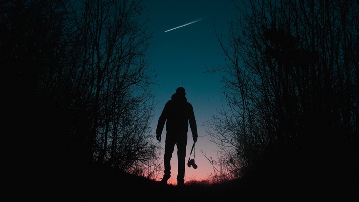 Silhouette of a man with a camera at dusk