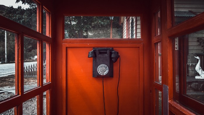 Vintage rotary telephone in a red phone booth