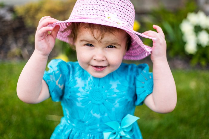 Baby girl in a blue dress and pink hat