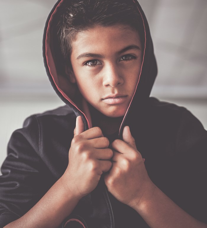 Boy in a black hoodie with red lining