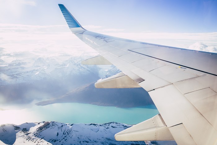Airplane wing flying over Perito Moreno Glacier and lake