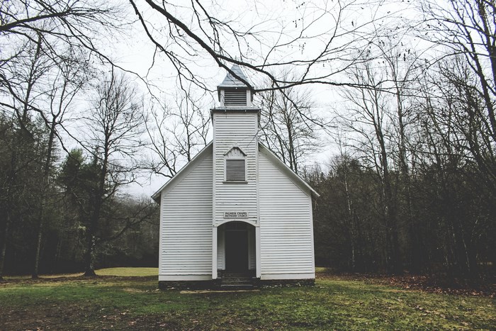 White wooden church in a forest setting