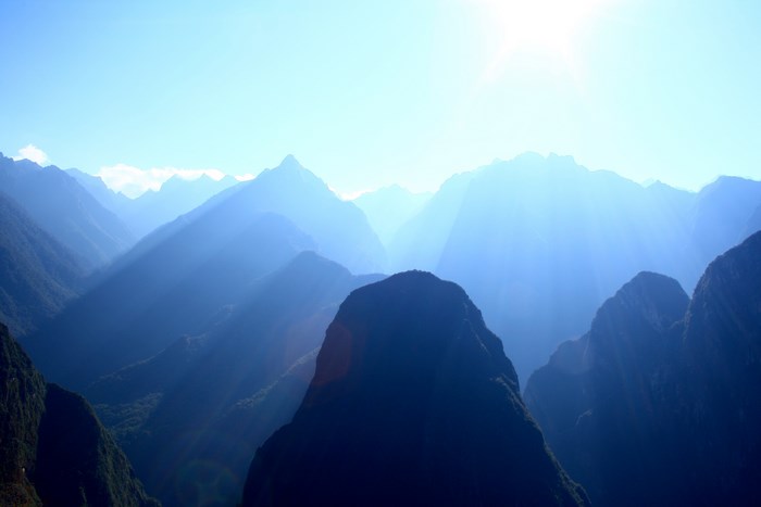 Machu Picchu mountain range at sunrise with sun rays