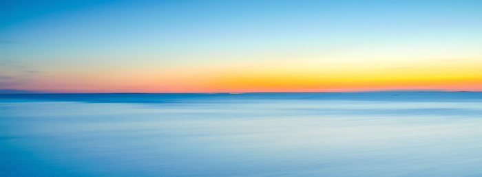 Calm Sea at Dawn or Dusk with Colorful Horizon