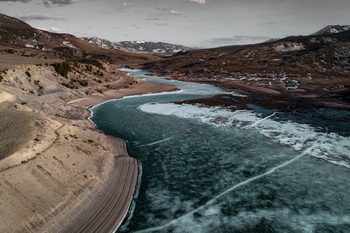 Frozen River Winding Through Mountains