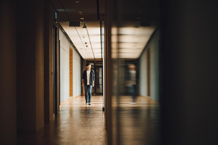 Man walking down a school hallway