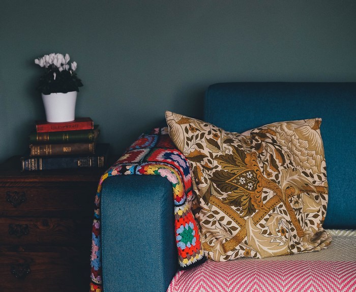 Stack of books with potted plant and sofa