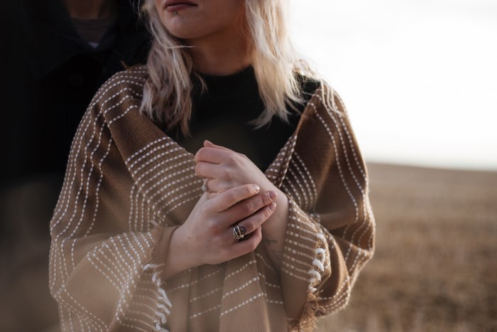 Woman wearing a brown shawl with white pattern