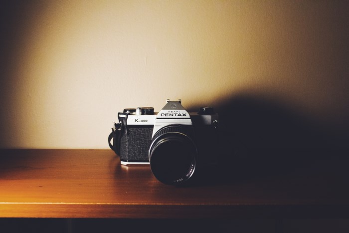 Asahi Pentax K1000 film camera on a wooden shelf