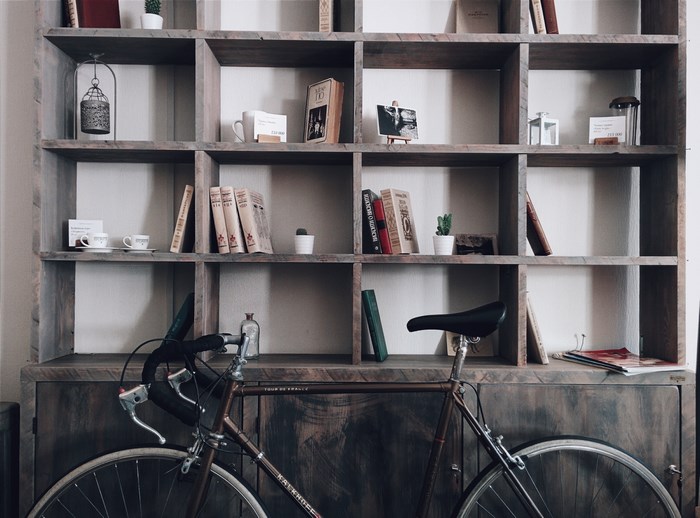 Wooden bookshelf with books and bicycle