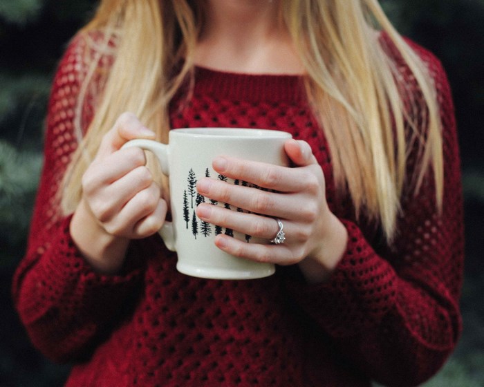 Woman in red sweater holding a mug