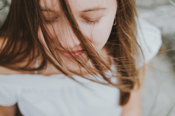Girl with eyes closed and hair blowing in the wind