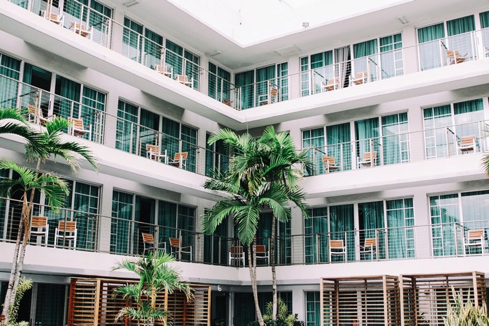 Hotel building with balconies and palm trees