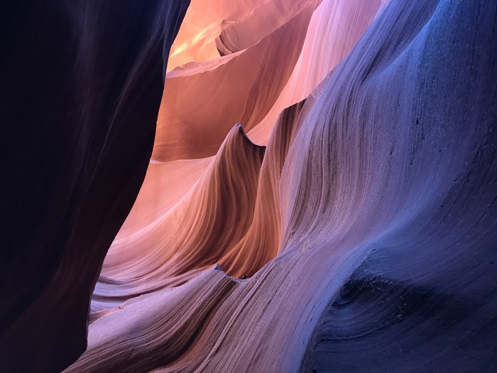 Antelope Canyon rock formations with pink, purple, and orange light