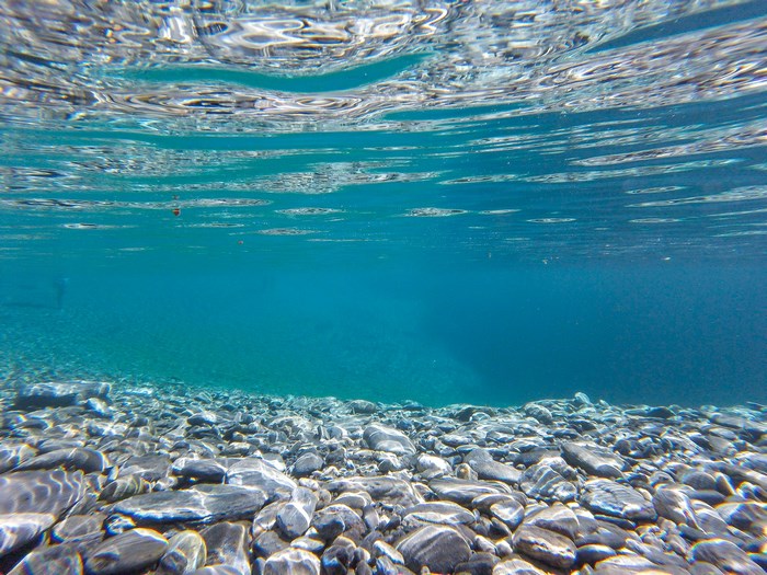 Clear Blue Underwater View with Pebbles