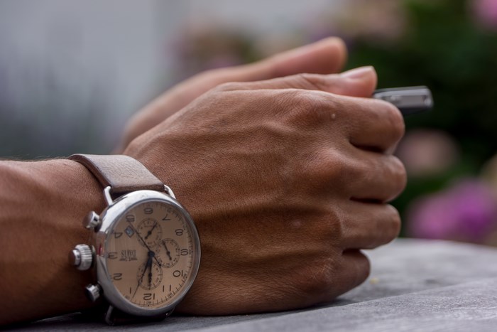 Man wearing a vintage watch and holding a phone