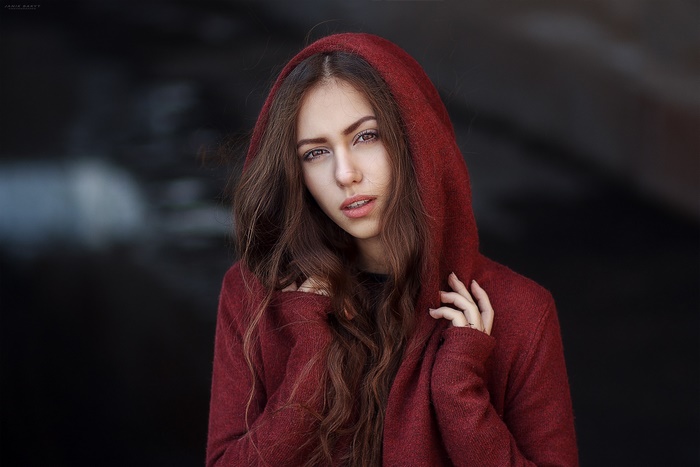 Woman with long brown hair wearing a red hood