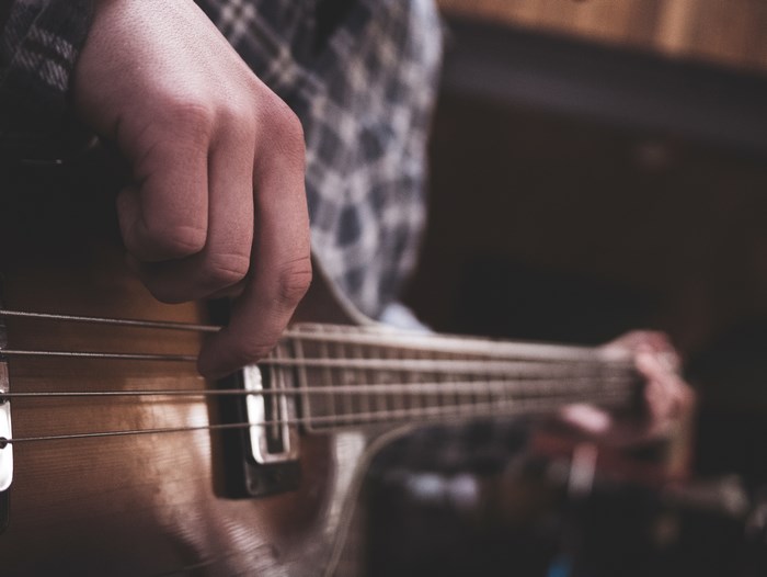 Person playing a bass guitar