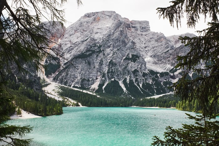 Turquoise lake and rocky mountain framed by trees