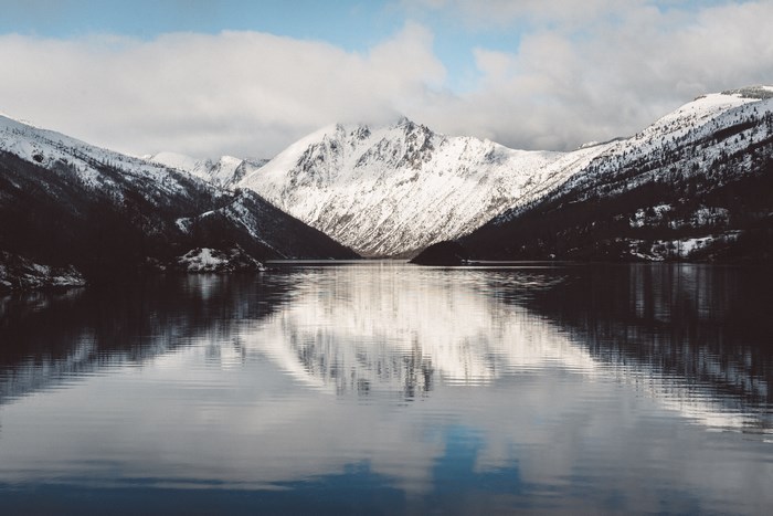 Snow-covered mountains reflected in a calm lake