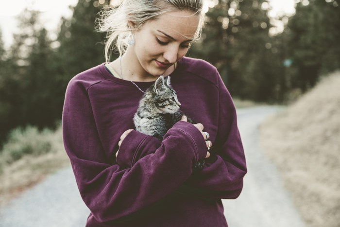 Woman holding a kitten outdoors