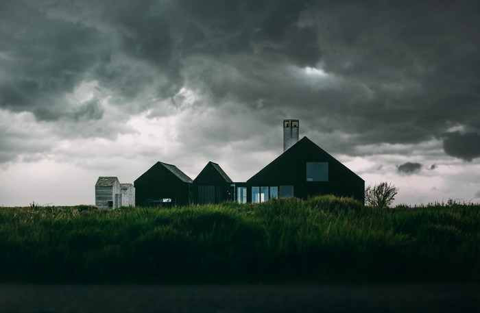 Dark modern houses under stormy clouds
