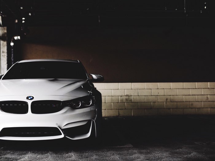 White BMW luxury car in a dark garage