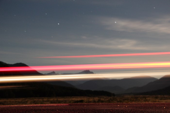 Light streaks over mountains at night