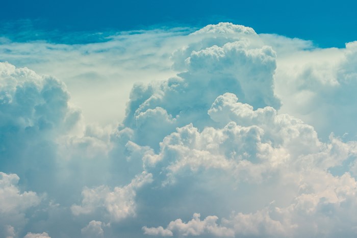 Fluffy white clouds against a bright blue sky