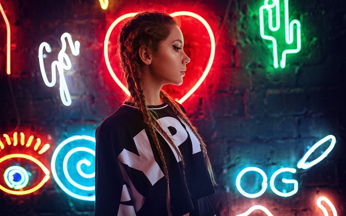 Woman with braids in front of neon signs