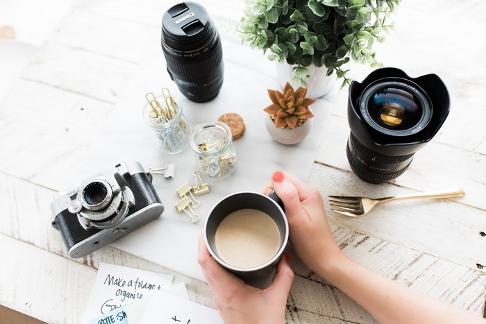 Canon Camera Lens and Coffee on a Table