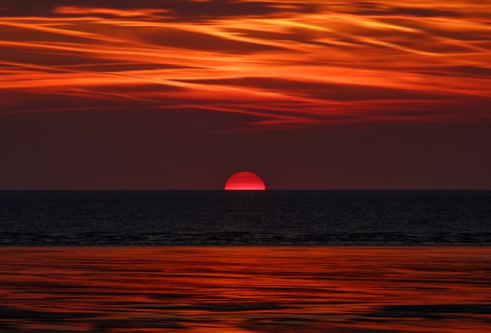 Sunset over the ocean with orange clouds
