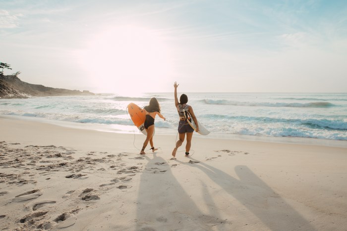 Two women with surfboards on Prainha beach in Rio de Janeiro