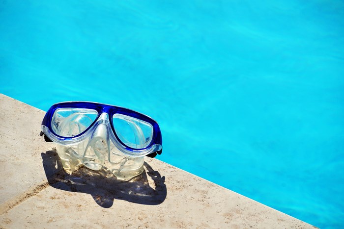 Scuba mask on the edge of a swimming pool