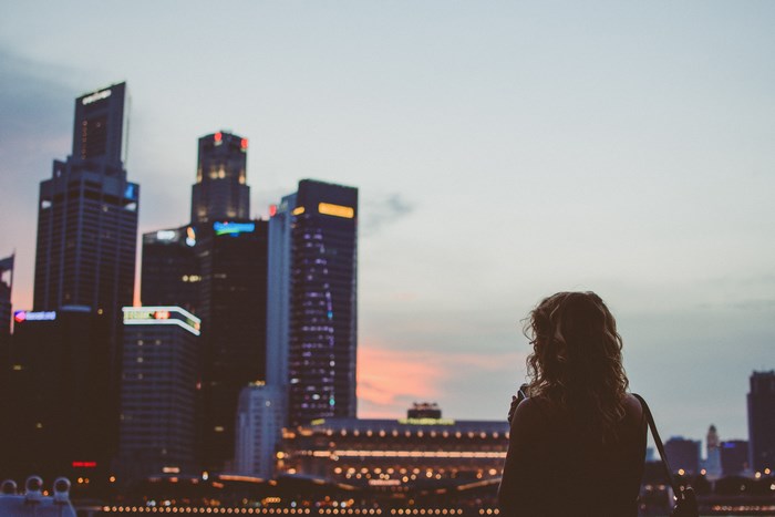 Woman looking at Singapore skyline at dusk