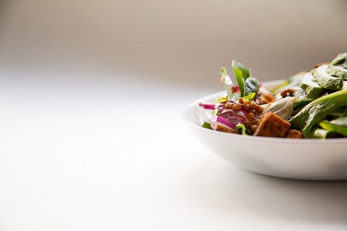 Healthy vegan salad with tofu and lentils in a white bowl