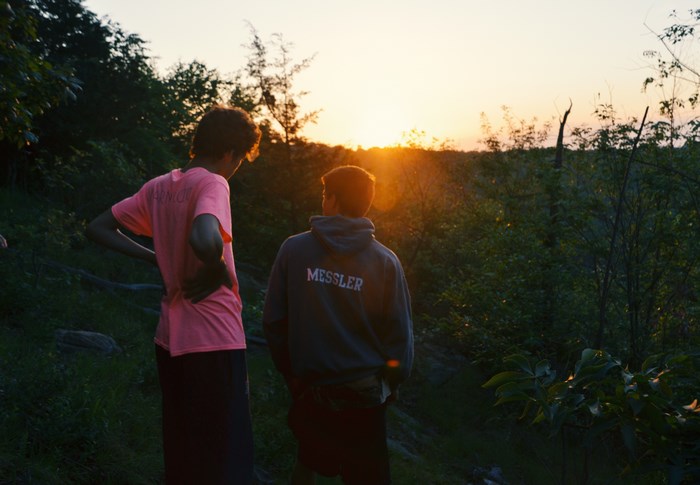 Two people watching the sunset in a forest