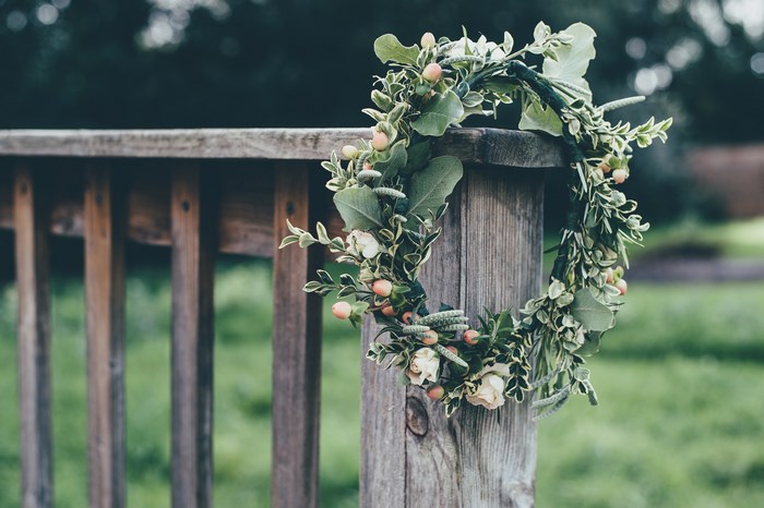 Floral crown with berries and roses on a wooden fence