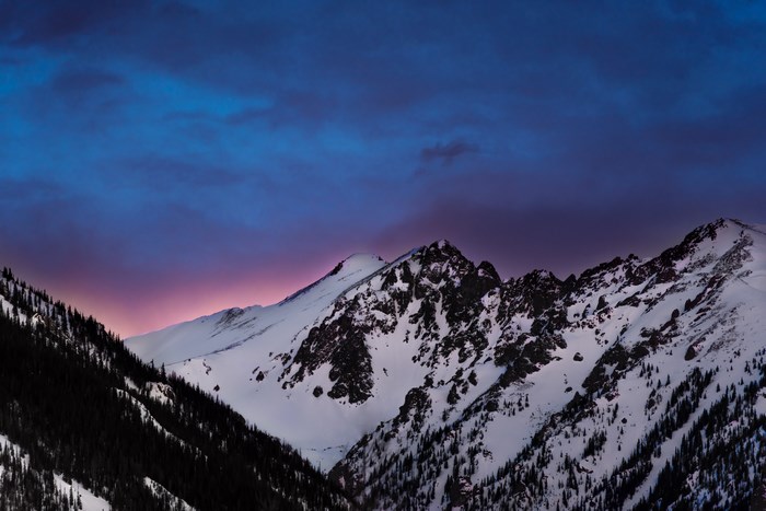 Snowy mountains at dusk with colorful clouds