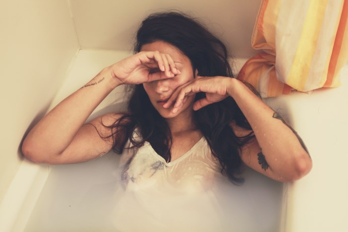 Woman with tattoos in a bathtub