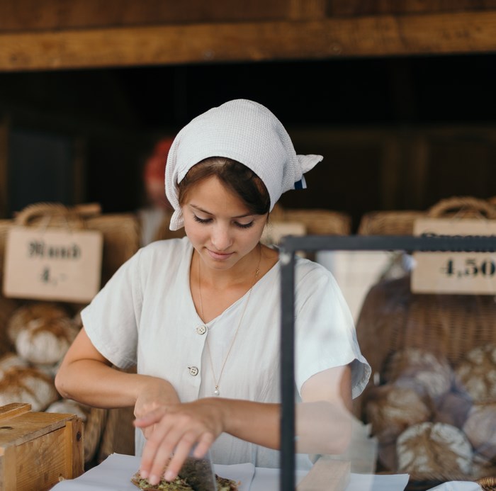 Woman working at a bakery market stall