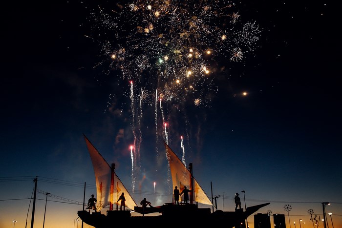People on a boat watching fireworks at sunset