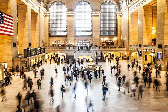 Grand Central Terminal interior with blurred crowd and American flag